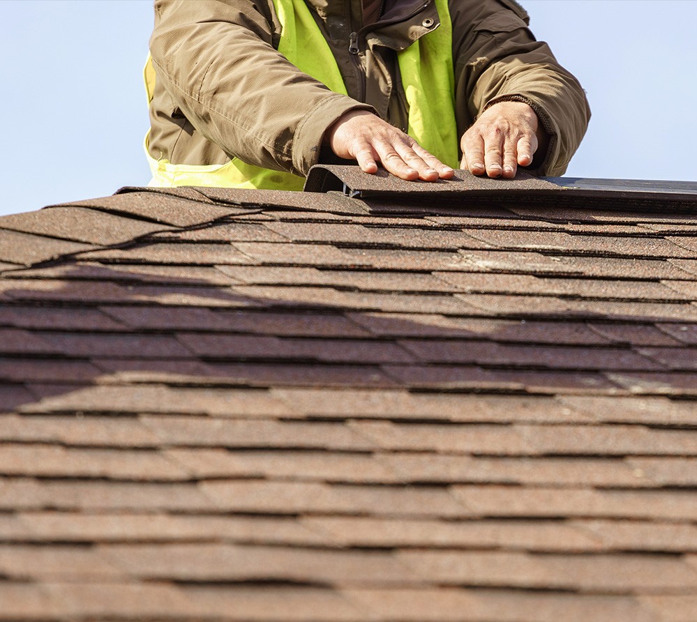 Roof inspector checking roof shingles