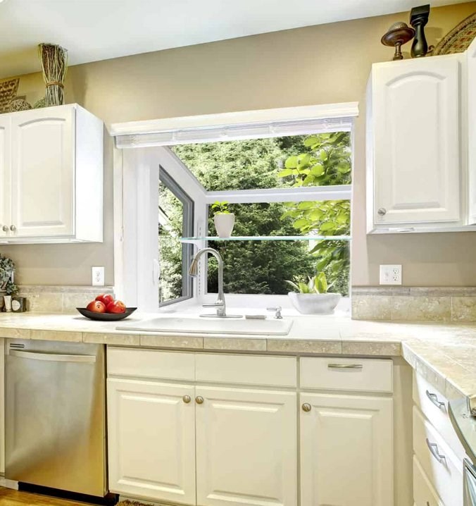 White garden window in kitchen holding small green plants