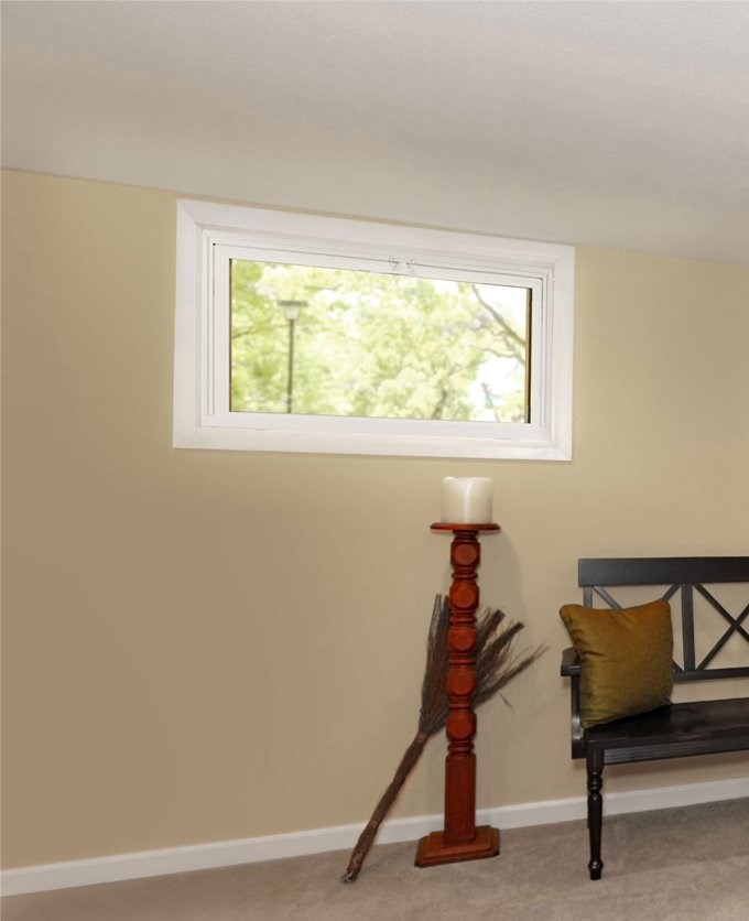 Large, white hopper window installed in home basement